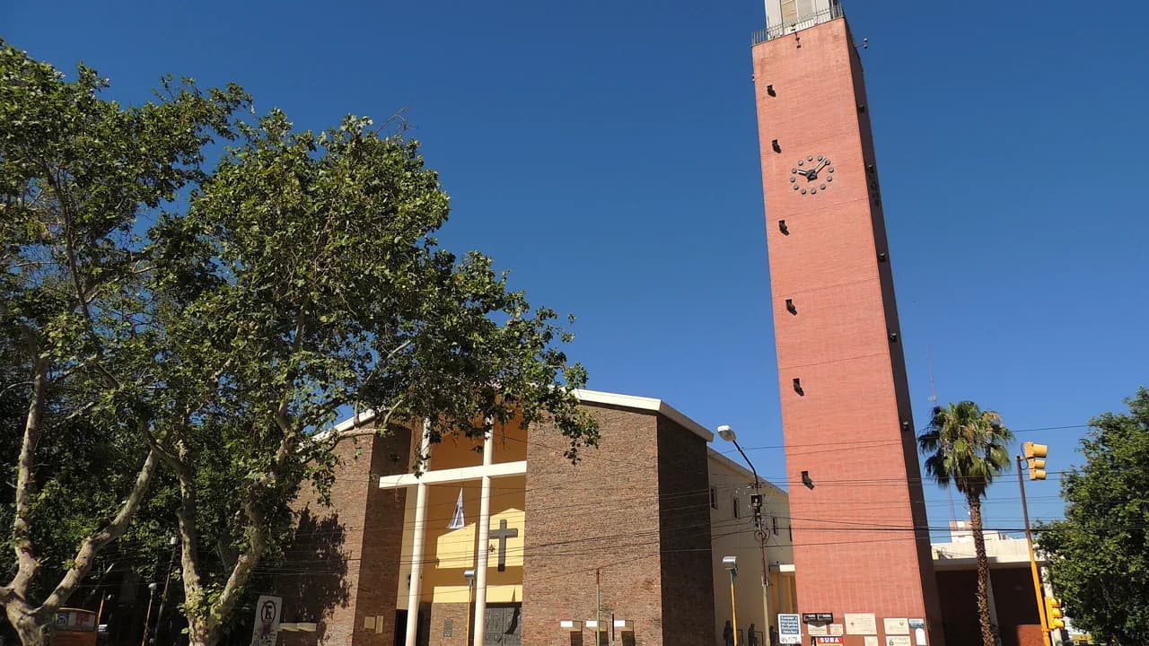 Catedral de San Juan: nave de ladrillo, cruz y torre con reloj